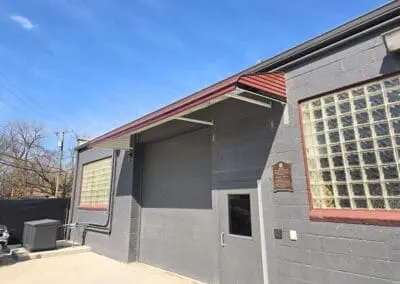 Client building with a gray exterior and reddish-brown awning built by Wayne Craft