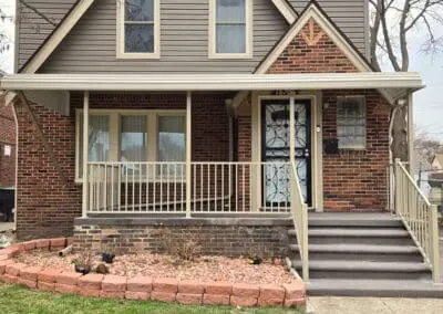 Michigan brick home with beige aluminum awning and matching railing built by Wayne Craft