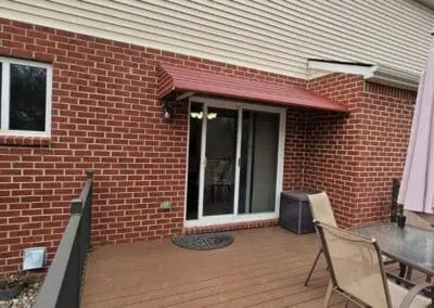 Back patio of a Michigan brick home with red aluminum awning built by Wayne Craft