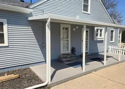 Side view of a Michigan home with blue siding and a white aluminum awning built by Wayne Craft