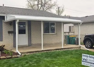 Front porch of a Michigan brick home featuring a white aluminum awning built by Wayne Craft