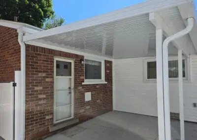 Side view of back patio of a Michigan home featuring a white aluminum awning built by Wayne Craft