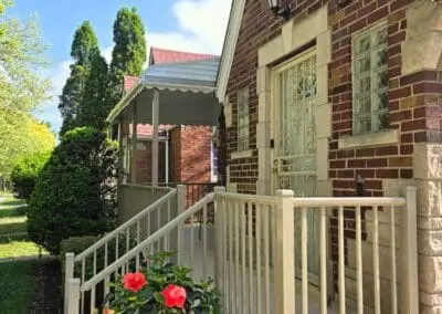 Michigan brick home with beige aluminum awning and matching railing built by Wayne Craft