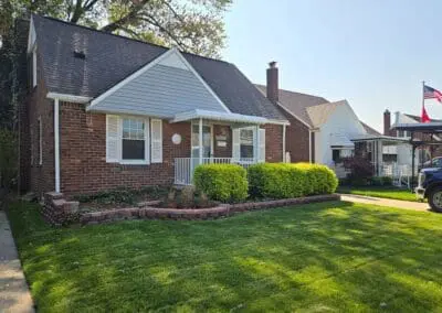Street view of a front porch of a Michigan brick home featuring a white aluminum awning and railing built by Wayne Craft