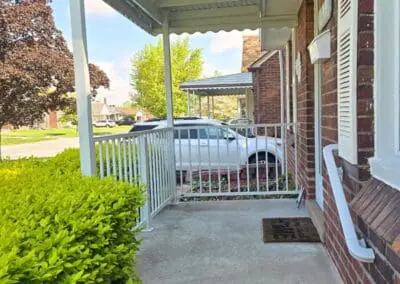 Front porch of a Michigan brick home featuring a white aluminum awning and railing built by Wayne Craft