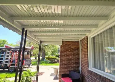 Porch featuring a white aluminum awning and black railing built by Wayne Craft