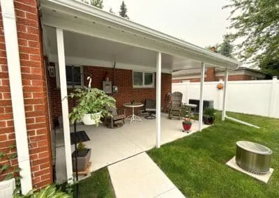 Red brick residential home with a white awning and railing built by Wayne Craft